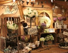 an assortment of flowers and other items on display in a room with bunting flags