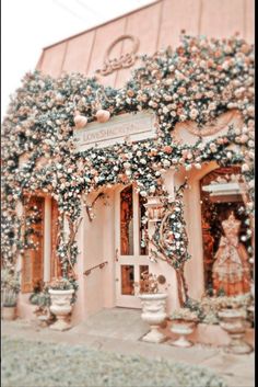 an old fashion store with lots of flowers on the front