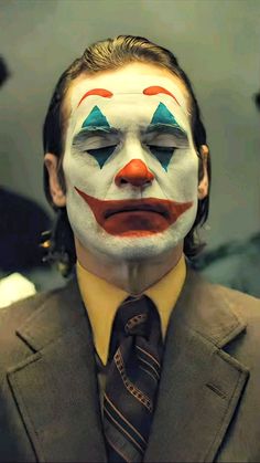 a man in a suit and tie with his face painted like a clown