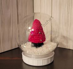 a snow globe with a small red christmas tree in it