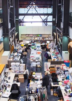 an overhead view of people working at desks in a large room with lots of books