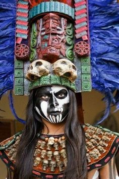 a woman with painted face and feathers on her head