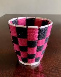 a pink and black cup sitting on top of a wooden table