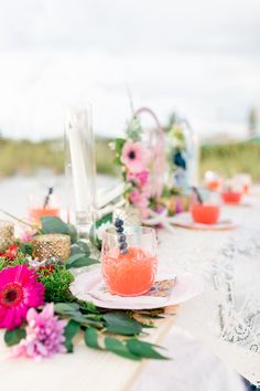 the table is set with flowers and drinks for an outdoor wedding reception or bridal party