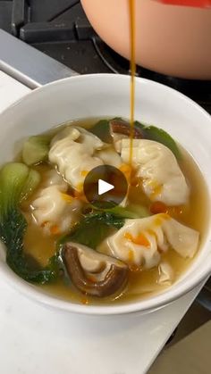 a white bowl filled with soup sitting on top of a stove