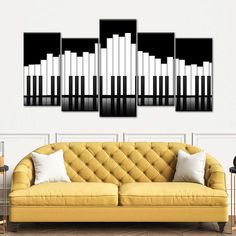 a couch sitting in front of a wall with piano keys on it's side