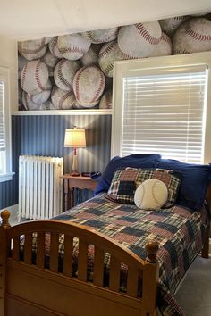 a baseball themed bedroom with blue walls and plaid bedspread, wooden headboard