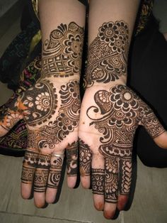 two hands with henna tattoos on them