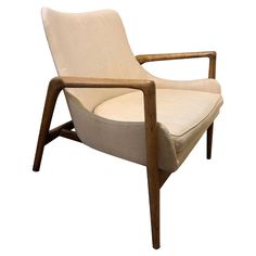 a white chair with a wooden frame and beige upholstered fabric on the back