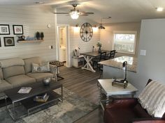 a living room filled with furniture next to a kitchen