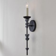 a candle is lit on the wall next to a light fixture that has been placed in front of it