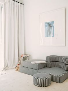 a living room with black and white striped furniture in front of a painting on the wall