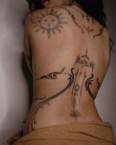 a woman's back with tattoos on it