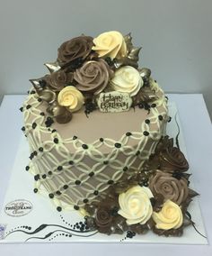 a cake decorated with flowers on top of a white table cloth covered in chocolate frosting