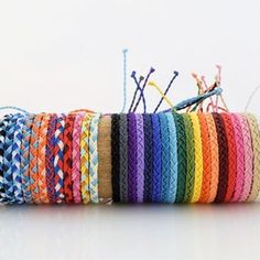 a roll of multicolored thread sitting on top of a wooden spool