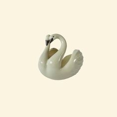 a white ceramic swan sitting on top of a table