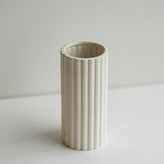 a white vase sitting on top of a table