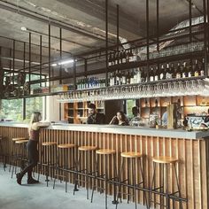 a bar with lots of stools and bottles on the shelves in front of it