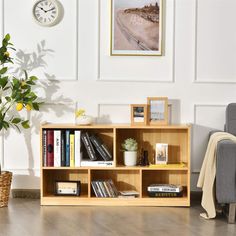 a living room with a couch, chair and bookshelf in front of a clock on the wall