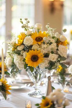 sunflowers and roses are arranged in clear vases on the dining room table