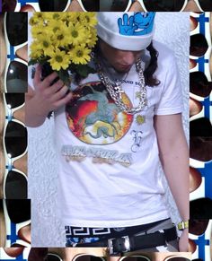 a man wearing sunglasses and a hat with flowers in front of his face while holding a bouquet of sunflowers