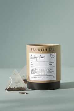 a tea with tape label next to a bag of loose black tea on a table