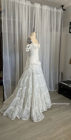 a wedding dress on display in front of a window