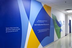 an office hallway with blue, yellow and green graphics on the wall next to it