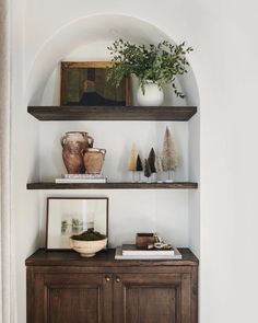 some shelves with vases and other items on them in a living room or dining room