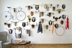 there are many pairs of shoes hanging on the wall next to an old bicycle parts display