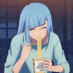 a girl with blue hair eating noodles from a cup