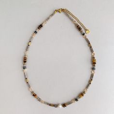 "This Mocha beaded necklace features mixture of cube, rectangular prism and round beads that made of brown, grey and beige natural stones, freshwater pearls and 18k gold plated components. It's perfect to pair with all of your winter outfits, and can also be the perfect gift for your fashion-forward friend or family member who loves layering necklaces with style.  This necklace is unisex, it's a great gift for men that love beaded choker or short necklace. - P R O D U C T - * Length: 38cm + 5cm extension / 15 - 17\"  * Materiel: Natural stones, real freshwater pearls and 18k gold plated. * Every piece is one of a kind: Natural pearls and stones are unique material, they are all different and may have some imperfections, that are often considered part of the beauty of natural gemstones. * H Natural Stone Bead Necklace, Short Pearl Necklace, Labradorite Beaded Necklace, Men Choker, Rectangular Prism, Xmas Gifts For Her, Layering Necklaces, Stone Beaded Necklace, Great Gifts For Men