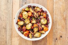 a white bowl filled with brussel sprouts on top of a wooden table