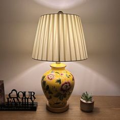 a lamp that is sitting on top of a table next to a potted plant