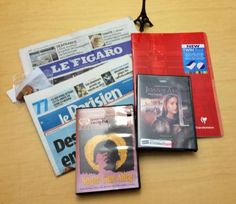 several dvds and newspapers sitting on a table