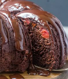 a chocolate bundt cake is on a wooden cutting board with a bite taken out of it