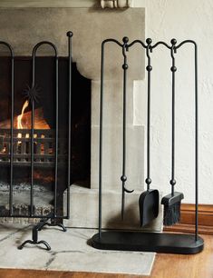 a fireplace with a fire in it and some black iron bars