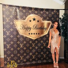 a woman standing in front of a happy birthday backdrop