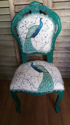 an old chair with a peacock painted on it