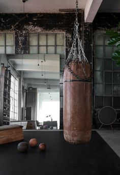 a punching bag hanging from the ceiling in an empty room with other objects on the floor