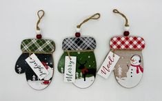 three christmas stockings hanging from twine with name tags and snowman on one ornament