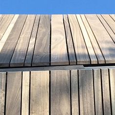 a bird is perched on top of a wooden deck