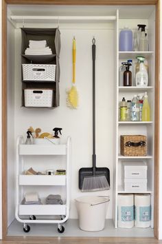 a white shelf filled with lots of cleaning supplies next to a bucket and mop