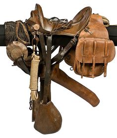 a horse saddle with several different types of tacks and accessories hanging on it's side