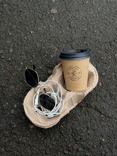 a cup of coffee and some headphones on the ground