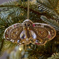 an ornament hanging from a christmas tree decorated with beads and sequins