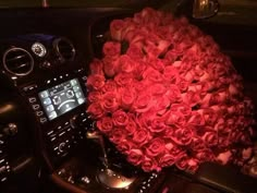 a bouquet of roses is sitting in the center console of a car's dashboard