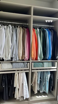 the closet is full of clothes and folded ones in different colors, shapes and sizes