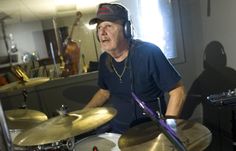 a man sitting in front of a drum set