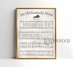 an old kentucky home sheet music print in a gold frame on a white wall with the words, my old kentucky home